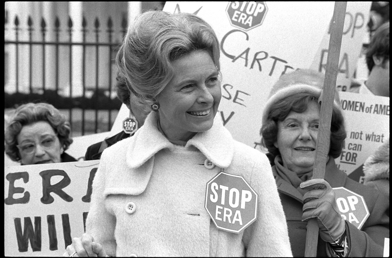 Phyllis Schlafly portant un badge Stop ERA lors d'une manifestation devant la Maison Blanche