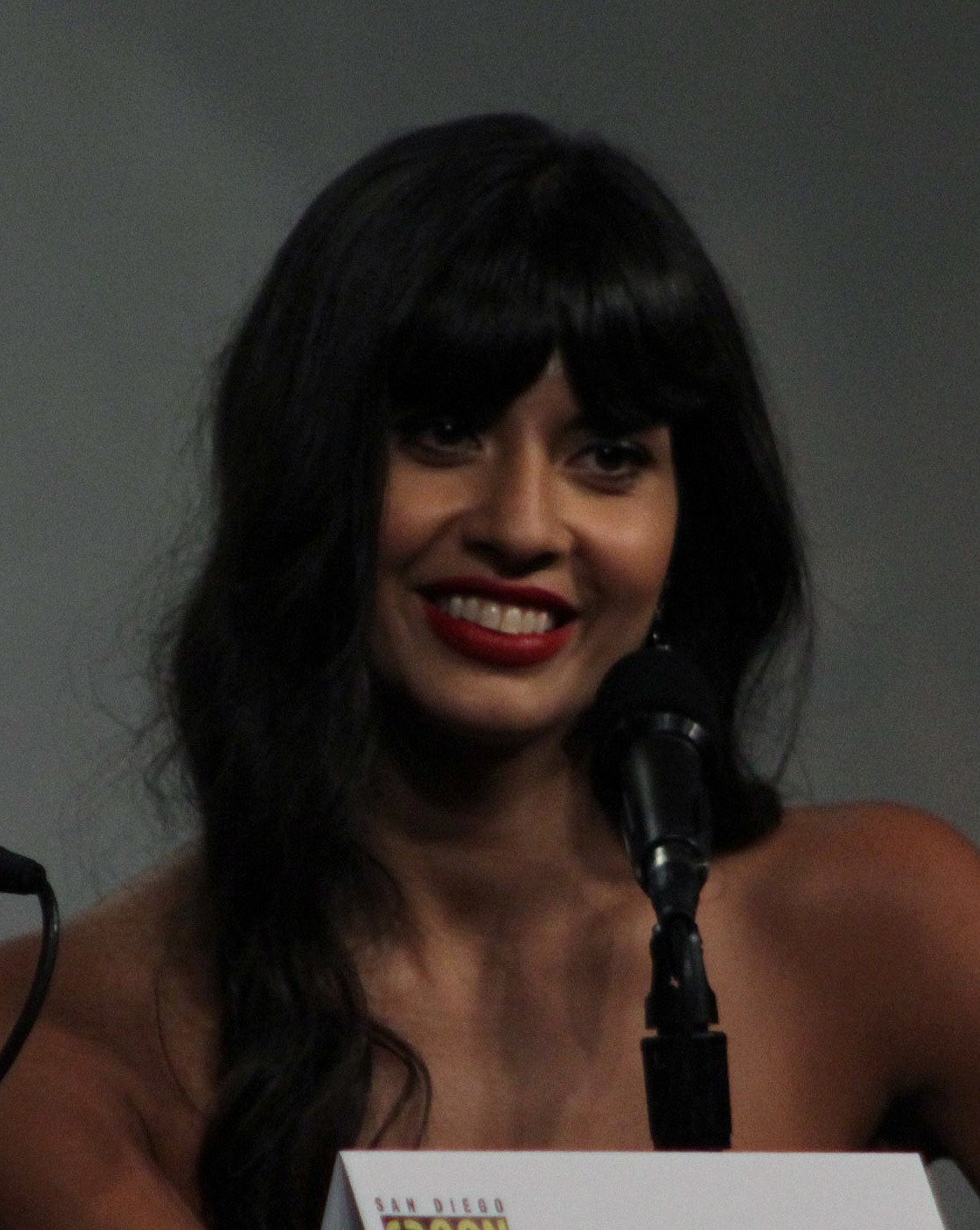 Jameela Jamil sourit devant un micro