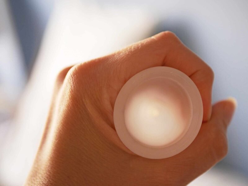 Une main tient une coupe menstruelle