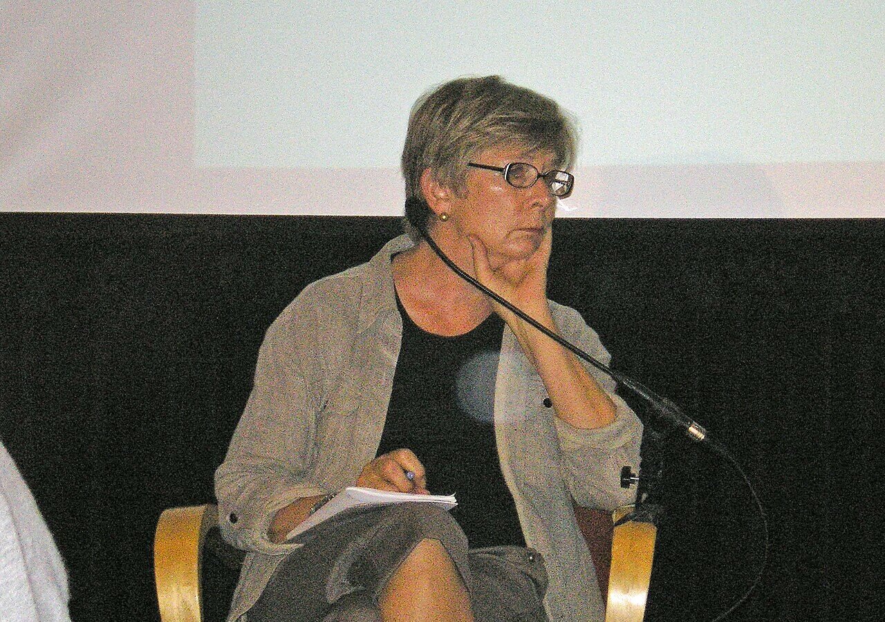 Barbara Ehrenreich assise devant un micro