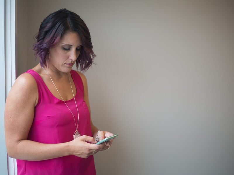 Une femme de profil regarde son téléphone