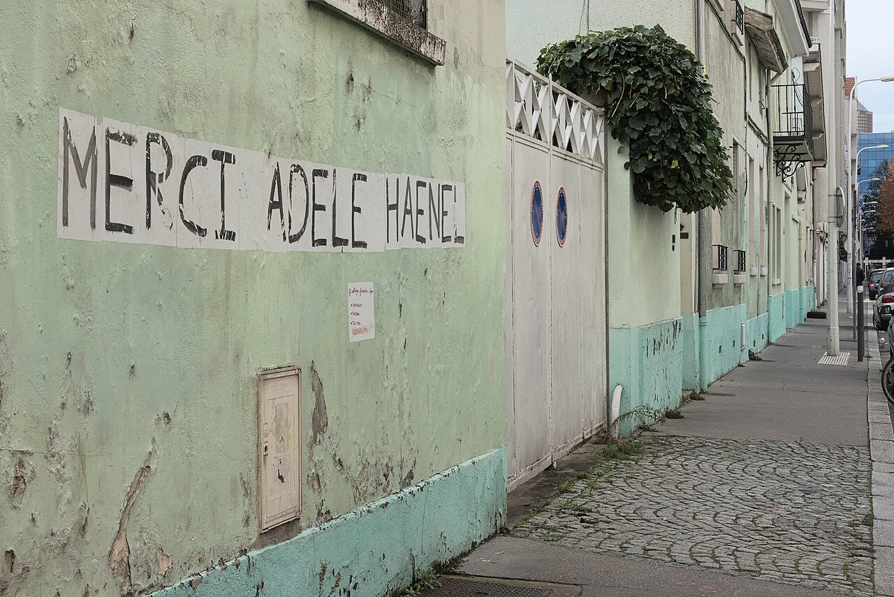 Un collage en lettres noires sur un mur : Merci Adèle Haenel